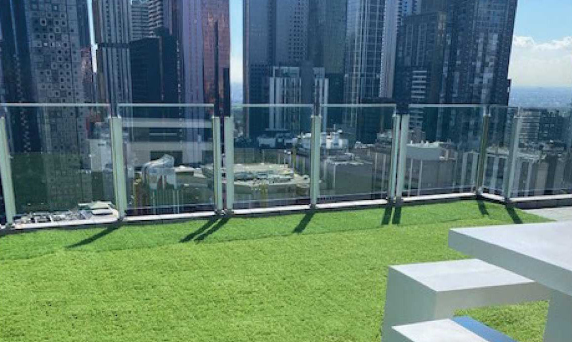 Rooftop terrace with artificial grass and patio tiles, offering a modern outdoor living space with city views